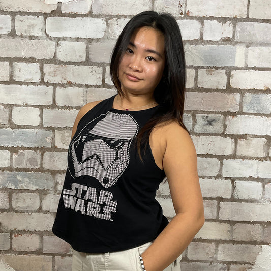 Person wearing a black Star Wars tank top in front of a brick wall. Storm Trooper Unwantee, recycled tank top made from preloved graphic tshirts, sustainable fashion, eco conscious shopping