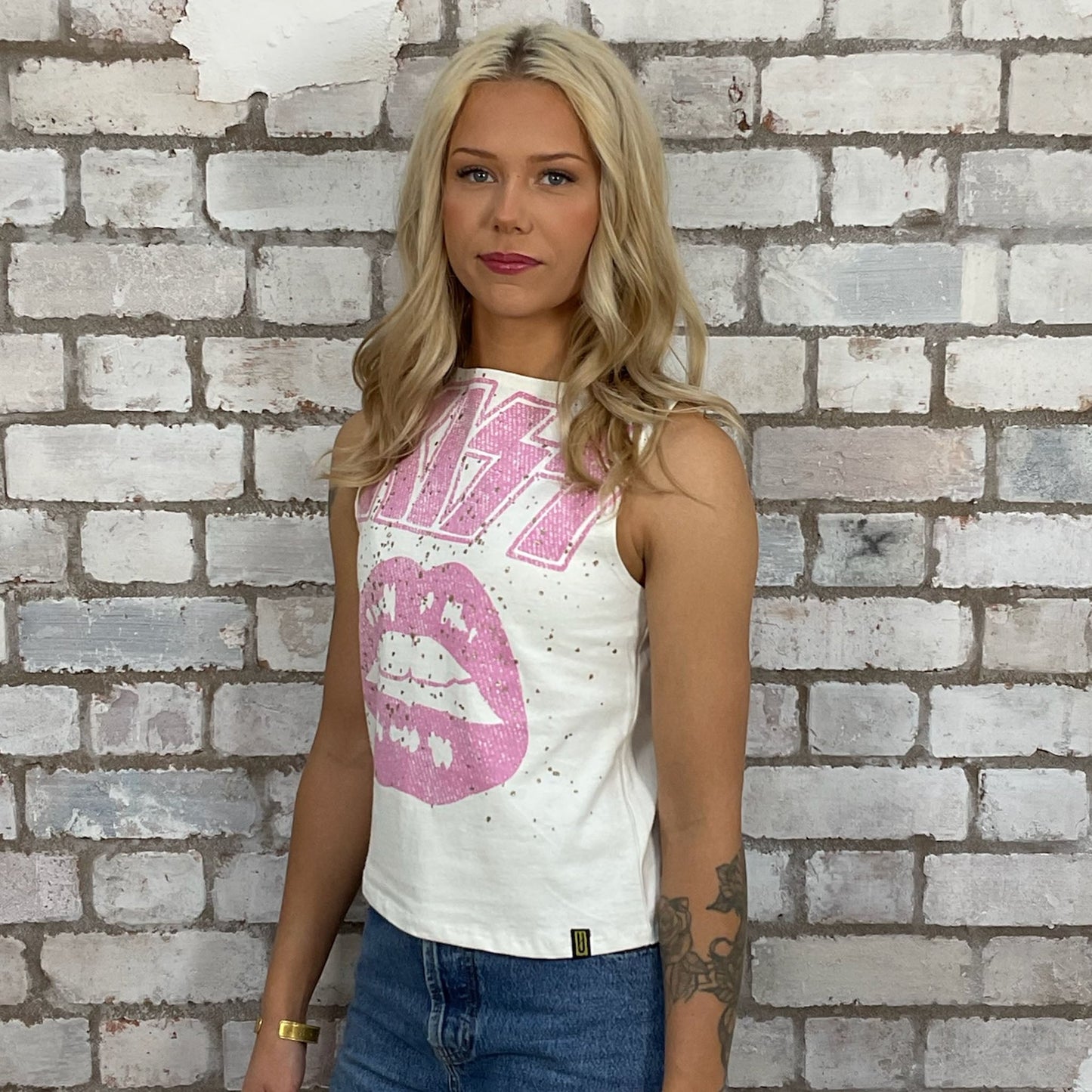 Graphic KISS band tshirt recycled into sleeveless racerback vest top, sustainable upcycled fashion, British recycled grunge brand, slow fashion, Punk Rock music style graphic tshirt upcycled by Unwantees, Pink text on cream tshirt upcycled in the UK by unwantees. Sustainable upcycled fashion. Graphic tshirt upcycled by Unwantees recycled tshirt otherwise destined for landfill.