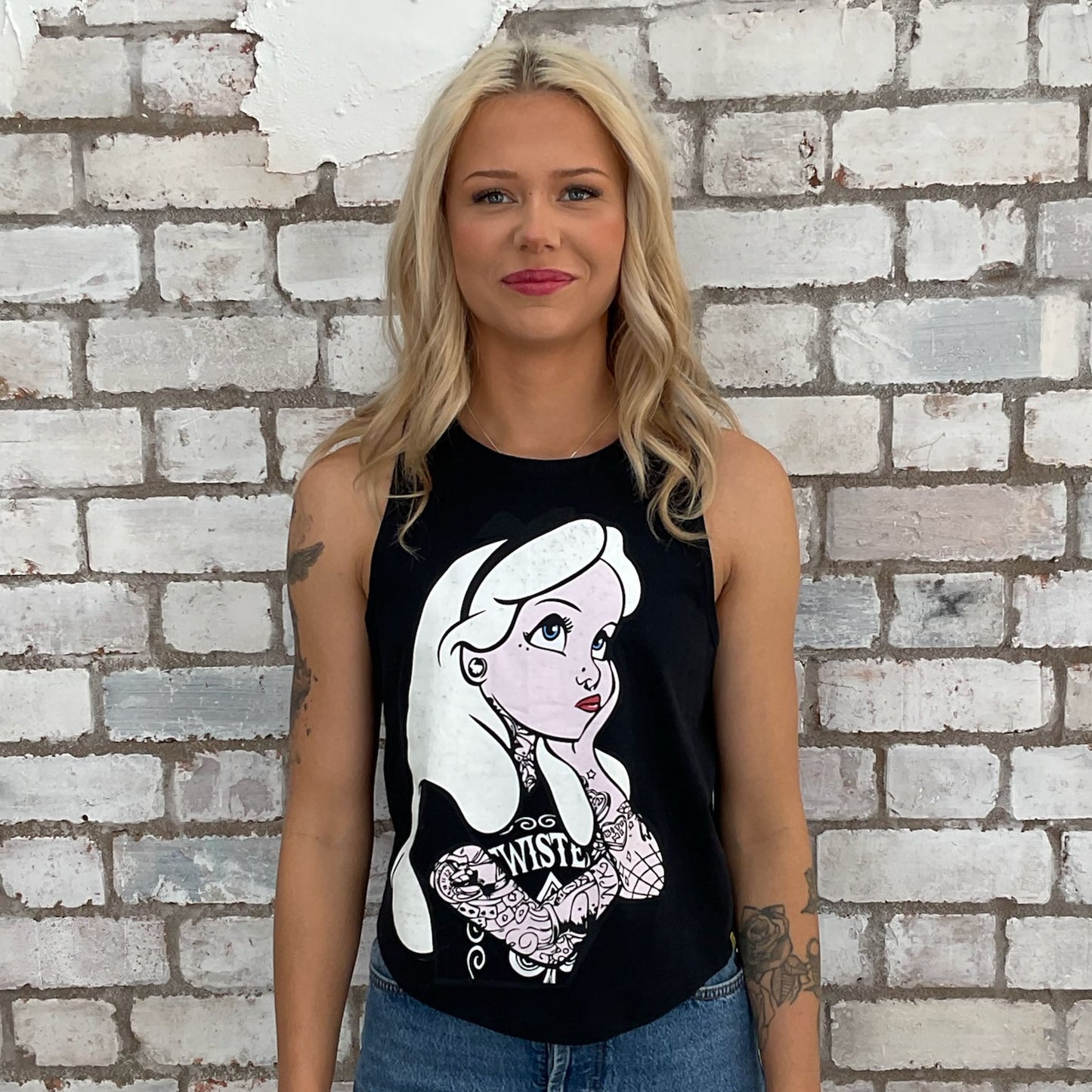 Alice in Wonderland with tattoos graphic tshirt upcycled by Unwantees, recycled racerback tank top, upcycled in the UK by unwantees. Sustainable fashion brand Unwantees recycled fairytale tshirt otherwise destined for landfill. Sustainable upcycled fashion, punk and rock Music Style, sleeveless tank top, sustainable upcycled fashion, British recycled fashion brand, slow fashion, eco conscious fashion