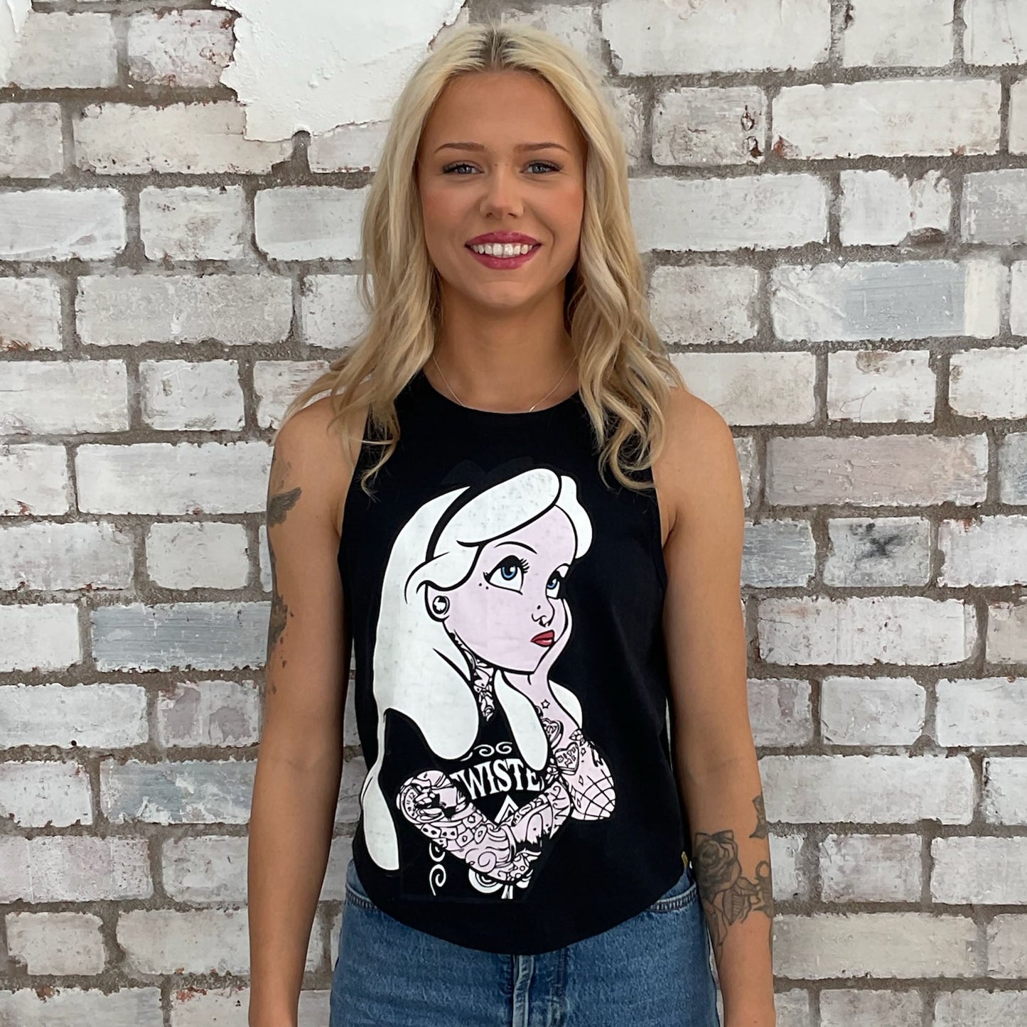 Tattooed Alice in Wonderland graphic tshirt upcycled by Unwantees, fairytale tattoo, recycled racerback tank top, upcycled in the UK by unwantees. Sustainable fashion brand Unwantees recycled fairytale tshirt otherwise destined for landfill. Sustainable upcycled fashion, punk and rock Music Style, sleeveless tank top, sustainable upcycled fashion, British recycled fashion brand, slow fashion, eco conscious fashion