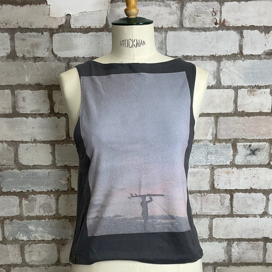 Black sheer sleeveless top on a mannequin against a brick wall. Lone Surfer graphic tank top, surfing top, rip curl printed vest top upcycled tshirt by Unwantees