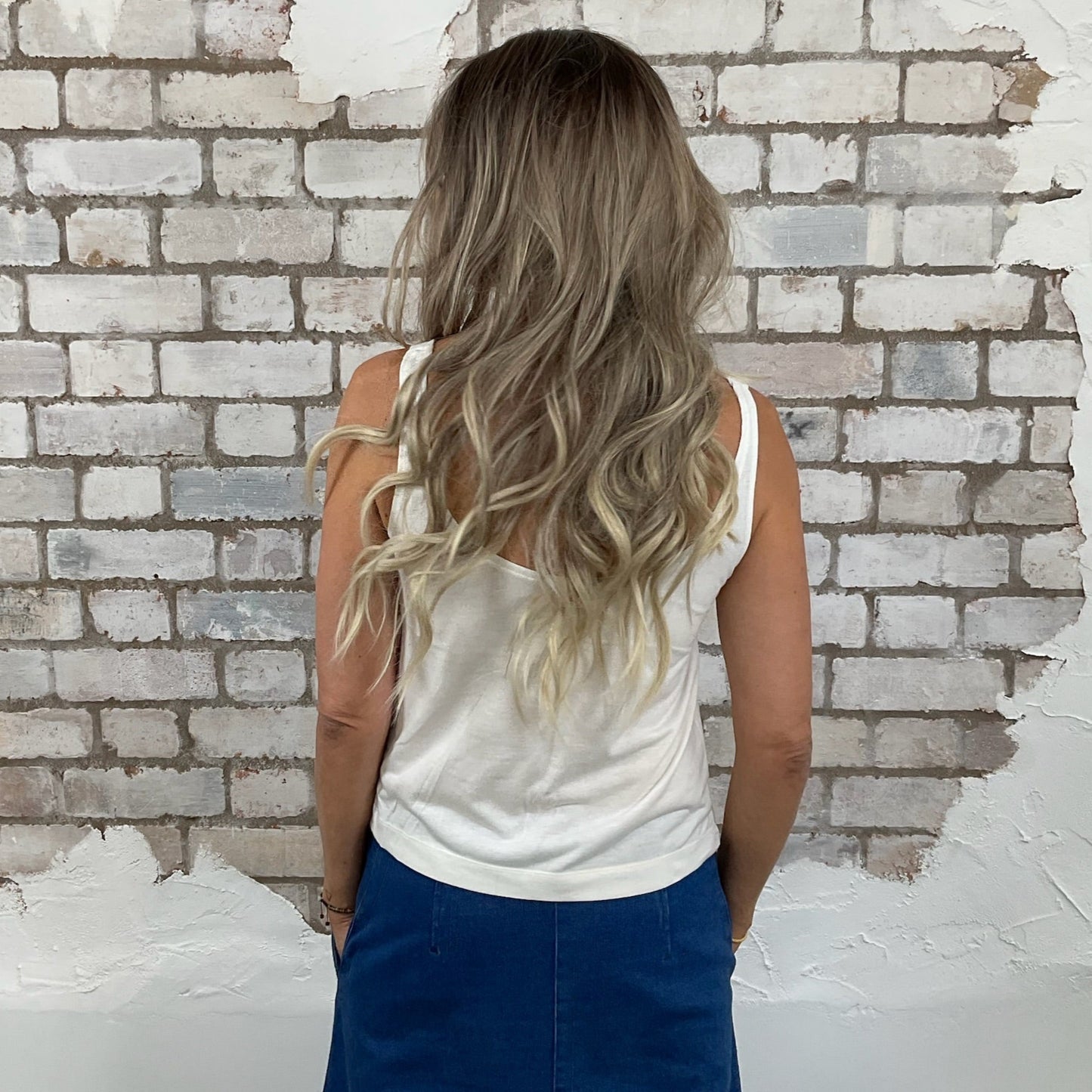 Woman with long blonde hair standing in front of a partially demolished brick wall. Scoop Neck Unwantee by www.unwantees.co.uk, up cycle clothing project