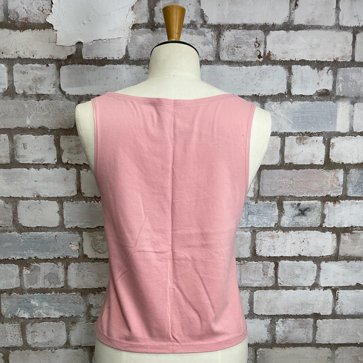 Pink sleeveless top on a mannequin against a brick wall. Snoopy Unwantees, Snoopy pink tank top, Snoopy High Neck Top, Snoopy Vest, Classic Unwantee Slash Neck Style, Pink