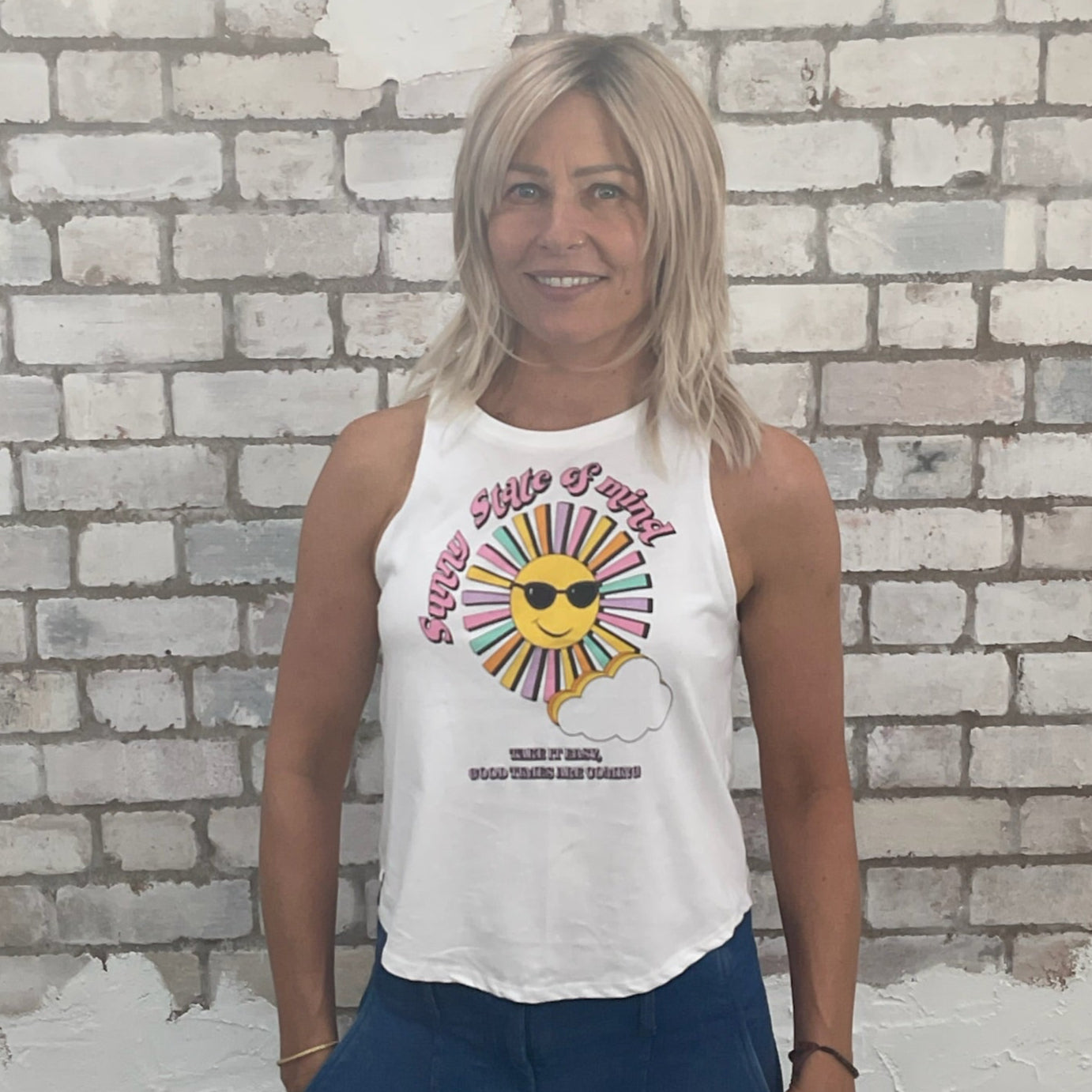 Woman wearing a white tank top with a colorful graphic design against a light brick wall. sustainable fashion UK
eco-friendly clothing UK
upcycled t-shirts / upcycled tank tops
ethical fashion brand UK
zero waste clothing
slow fashion brand
made in Britain clothing
sustainable vest tops