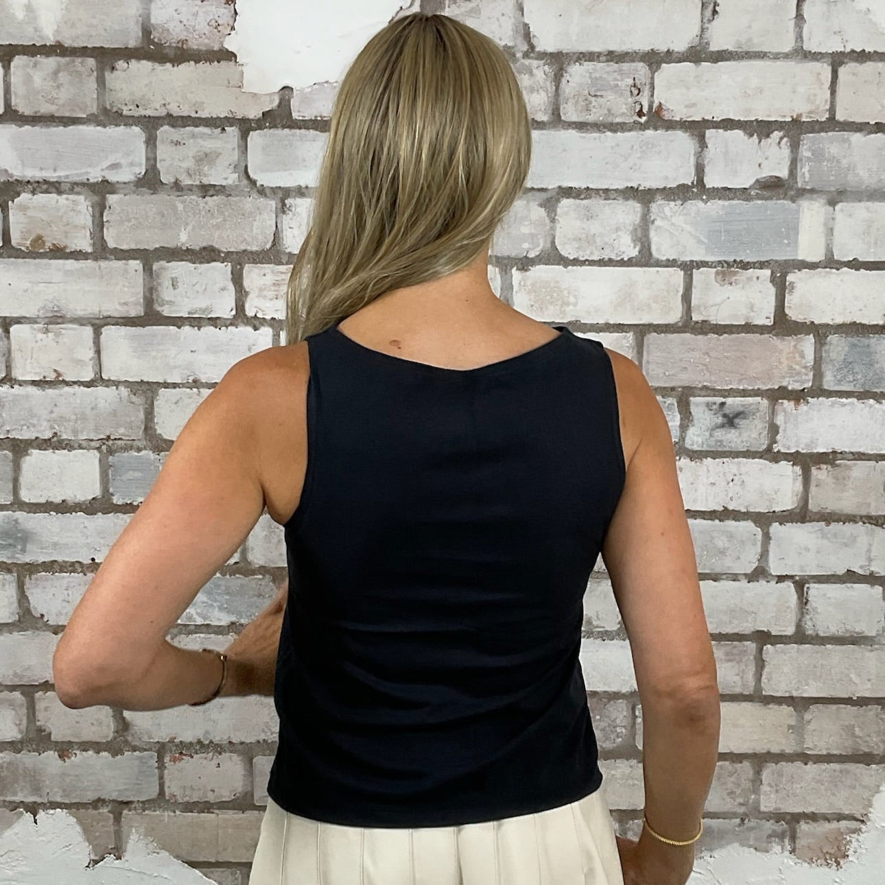 Woman standing in front of a white brick wall in a black Unwantee, sustainable fashion UK
eco-friendly clothing UK
upcycled t-shirts / upcycled tank tops
ethical fashion brand UK
zero waste clothing
slow fashion brand
made in Britain clothing
sustainable vest tops