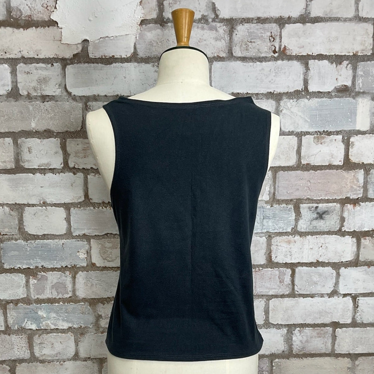 Black sleeveless top on a mannequin against a brick wall. Unwantees Slash Neck Tank Top