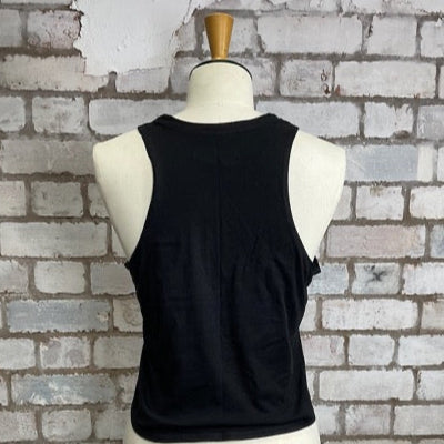 Black tank top on a mannequin against a textured brick wall. Unwantees tank top in slash neck style, black, recycled tshirt by Unwantees.com