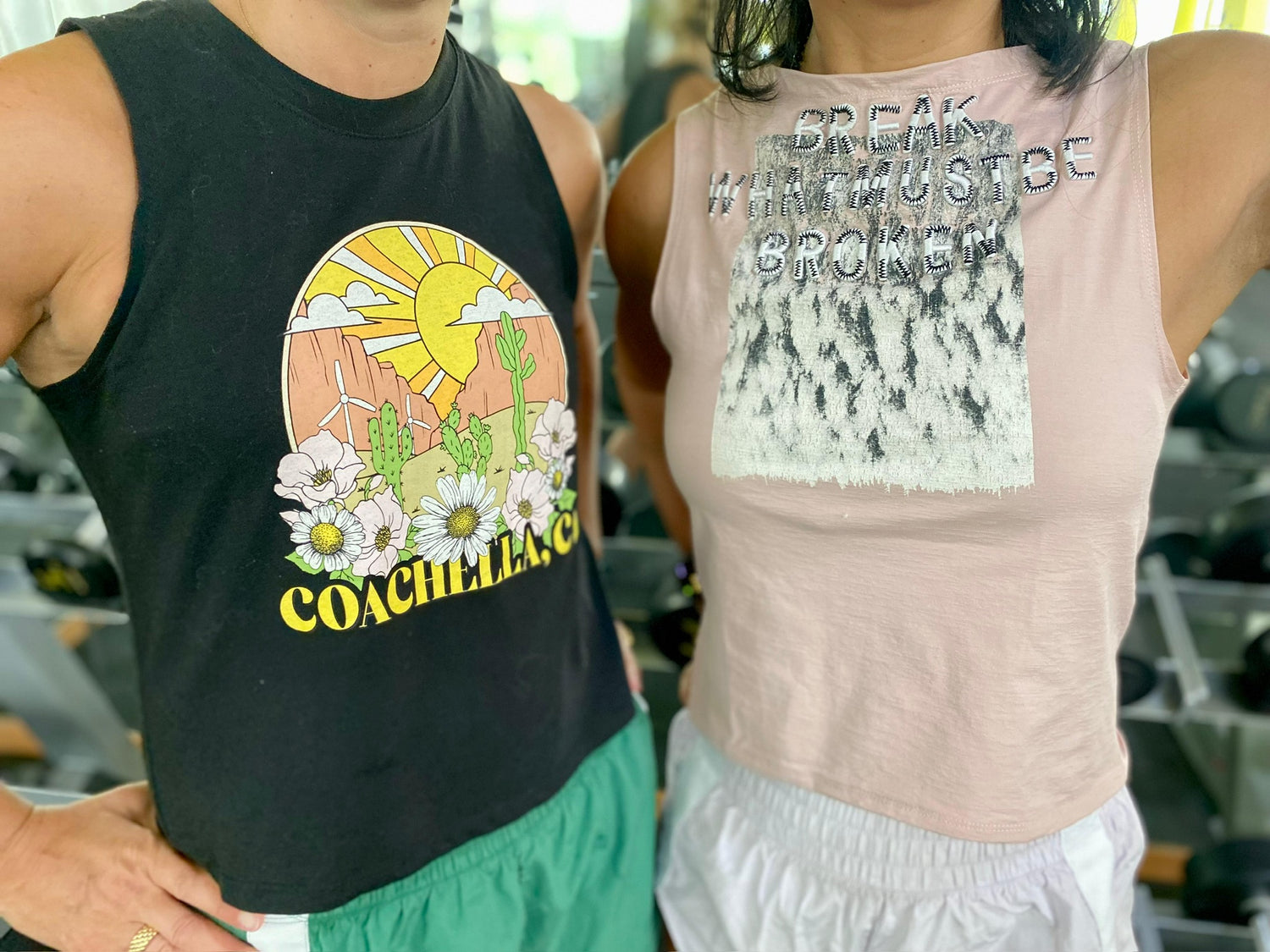 Two women wearing upcycled Unwantees tank tops in public, one pink and one black Coachella design