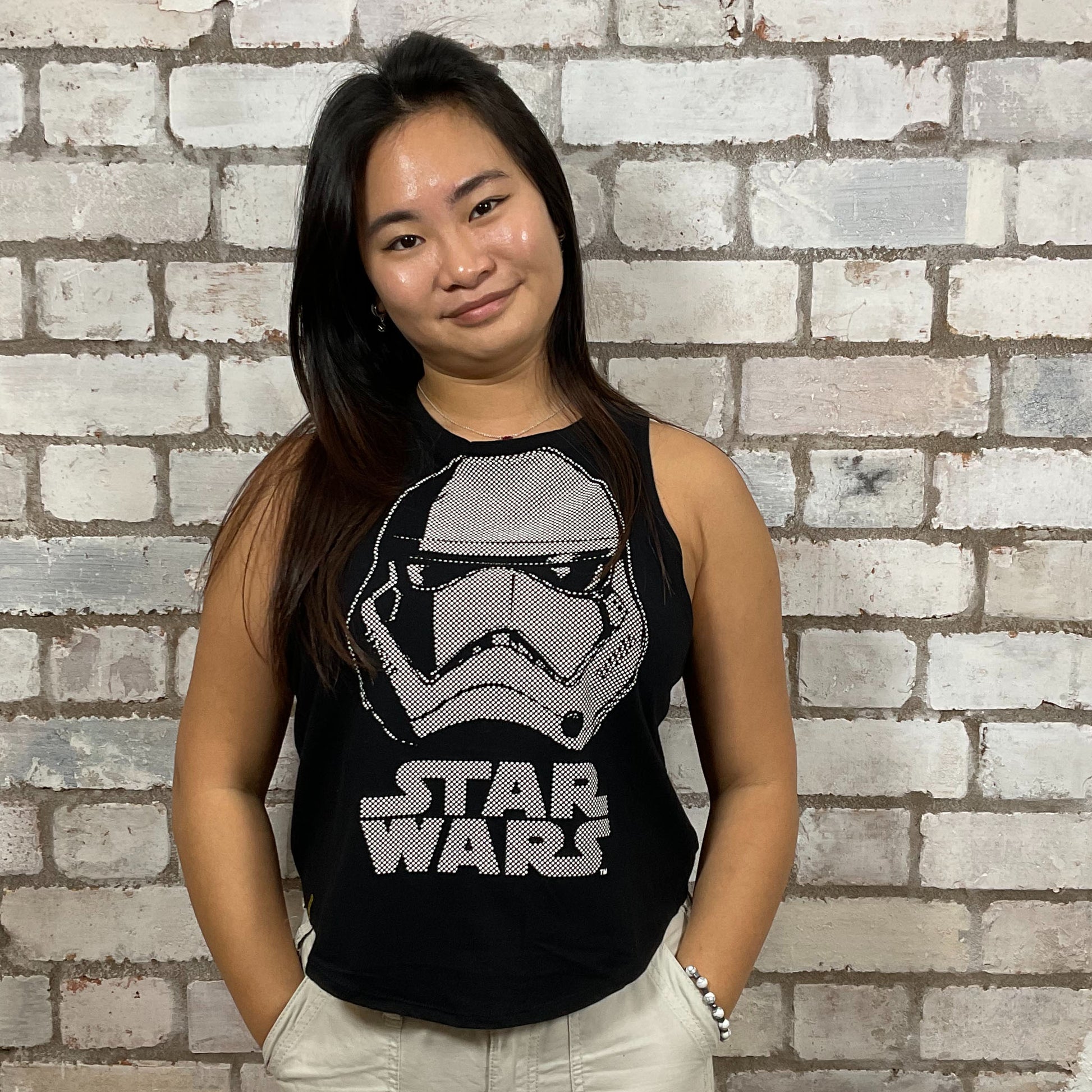 Person wearing a Star Wars tank top in front of a brick wall.  Storm Trooper Unwantee, recycled tank top made from preloved graphic tshirts, sustainable fashion, eco conscious shopping