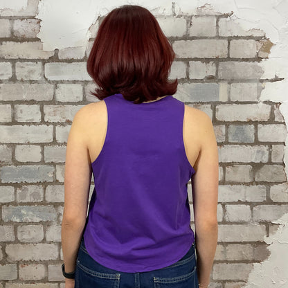 Person wearing a purple tank top standing against a brick wall.  Lazy Varsity style tshirt upcycled by unwantees in the uk, one of a kind tank tops