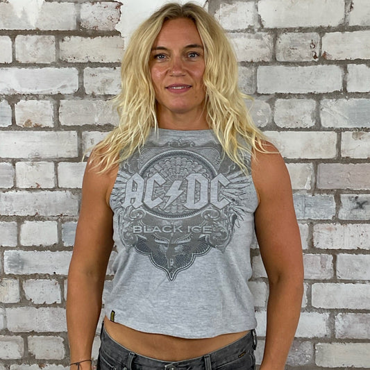 Person wearing an AC/DC tank top in front of a textured white brick wall, ACDC Black Ice tank top, high neck, crew neck ADC tank top, AC/DC vest top