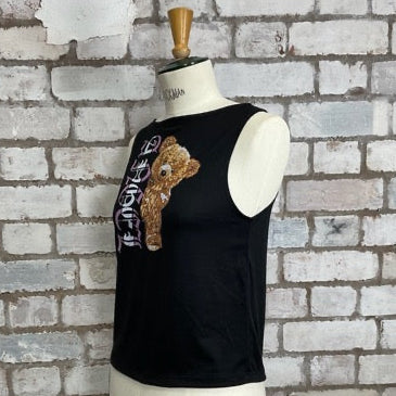 Black tank top with a teddy bear design on a mannequin against a textured brick wall.  Angel Teddy Bear Print tank top, Angel vest, High neck black sleeveless top, recycled by unwantees, up cycle made in Great Britain, cute teddy bear