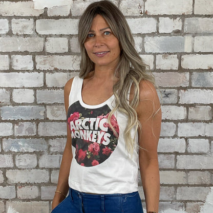 Woman wearing a tank top with a graphic design in front of a textured brick wall.  Arctic Monkeys Floral Tank Top, Vibrant coloured top by Arctic Monkeys Up Cycled recycled by Unwantees