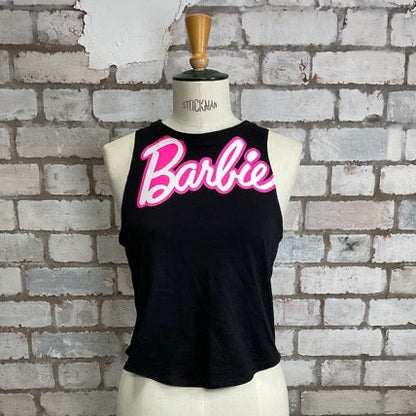 Black tank top with pink 'Barbie' text on a mannequin against a brick wall.  Barbie Tank Top, Barbie vest Top, Barbie life is fantastic in plastic, Unwantees slash neck style, recycled up cycle fashion