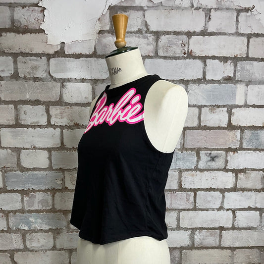 Black tank top with pink 'Barbie' text on a mannequin against a textured brick wall.  Black tank top with pink 'Barbie' text on a mannequin against a brick wall.  Barbie Tank Top, Barbie vest Top, Barbie life is fantastic in plastic, Unwantees slash neck style, recycled up cycle fashion. www.unwantees.co.uk