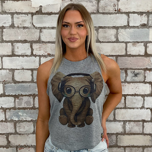 Woman wearing a gray tank top with an elephant design against a brick wall.  one-of-a-kind clothing
unique tank tops / unique vests
handmade clothing UK
reworked t-shirts UK
limited edition fashion
sustainable streetwear
sustainable tank tops
women’s eco fashion UK
