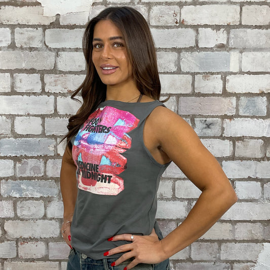 Woman wearing a sleeveless shirt with Foo Fighters band graphic design against a brick wall, one-of-a-kind clothing
unique tank tops / unique vests
handmade clothing UK
reworked t-shirts UK
limited edition fashion
sustainable streetwear
sustainable tank tops
women’s eco fashion UK
