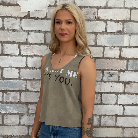 Woman wearing a tank top with funny text against a brick wall, vest ecycled project by unwantees, tshirt upcycle, sustainable fashion, slow fashion